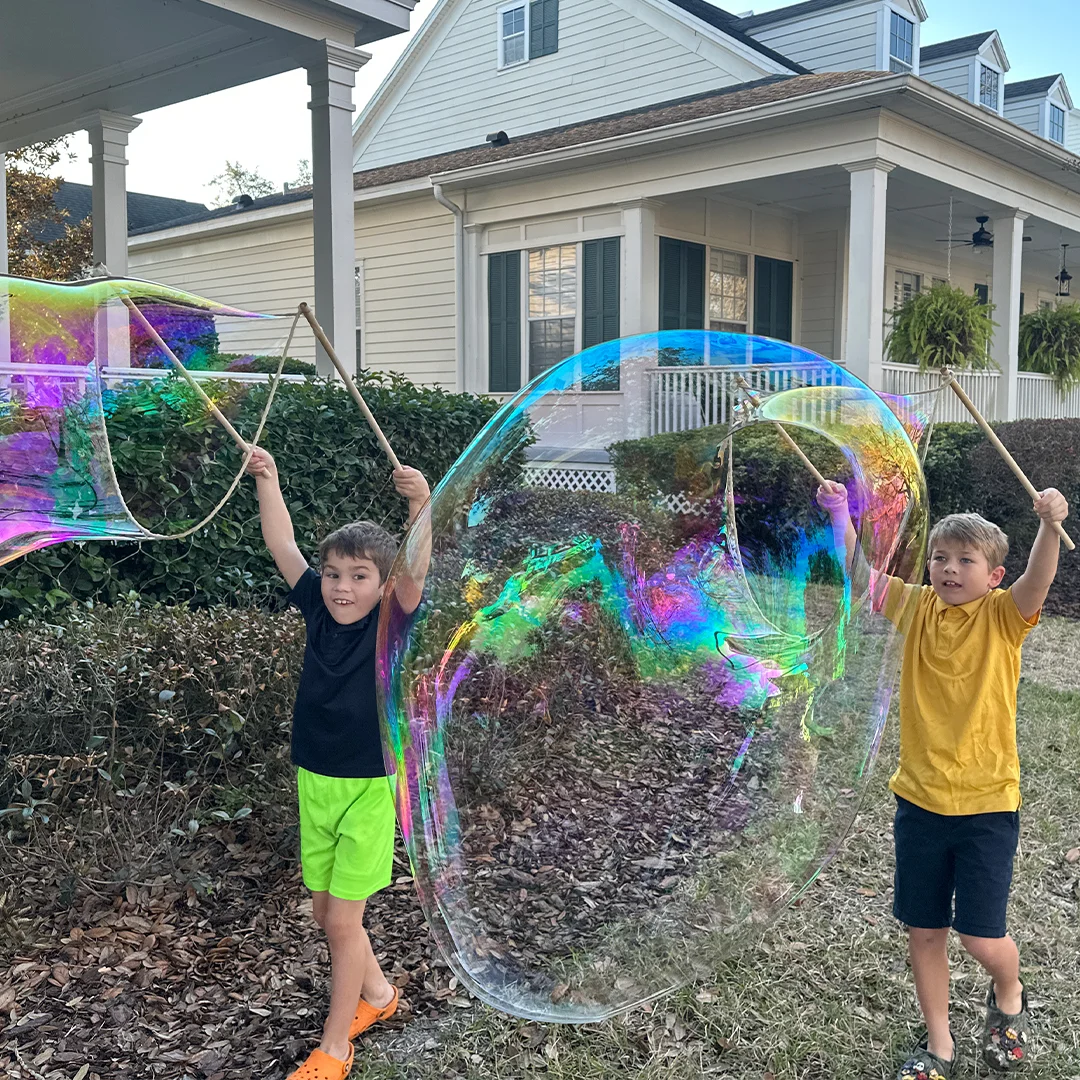 Original photograph showing two children opening real wooden BubbleStix string wands